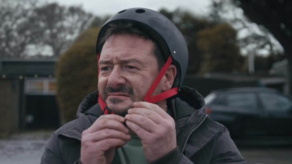 Man attempting to fasten a helmet on his head